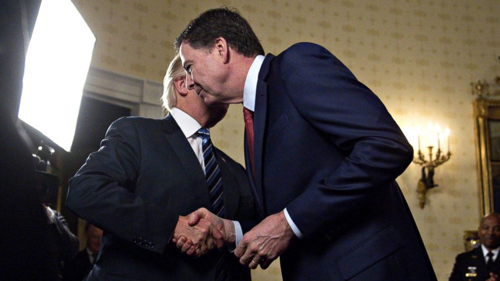 President Donald Trump, left, shakes hands with James Comey, director of the Federal Bureau of Investigation (FBI), during an Inaugural Law Enforcement Officers and First Responders Reception in the Blue Room of the White House in Washington, Jan. 22, 2017.