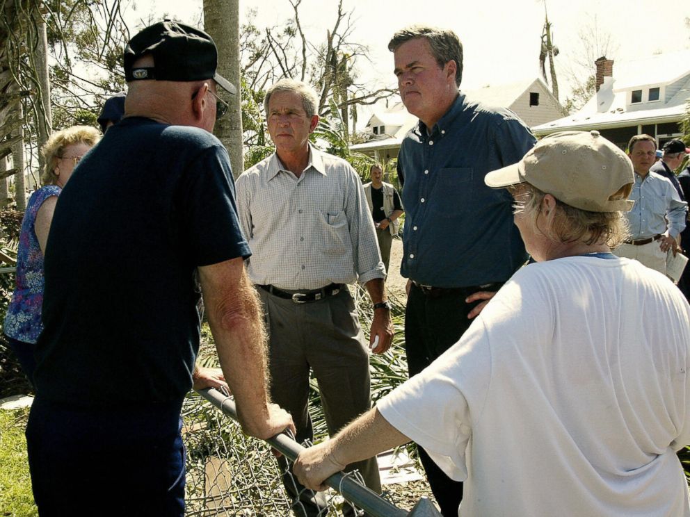 PHOTO: U.S. President George W. Bush (L) and his brother Florida Governor Jeb Bush (R) talk to local residents while touring the damage left by Hurricane Charley in Punta Gorda, Florida, on Aug. 15, 2004. 