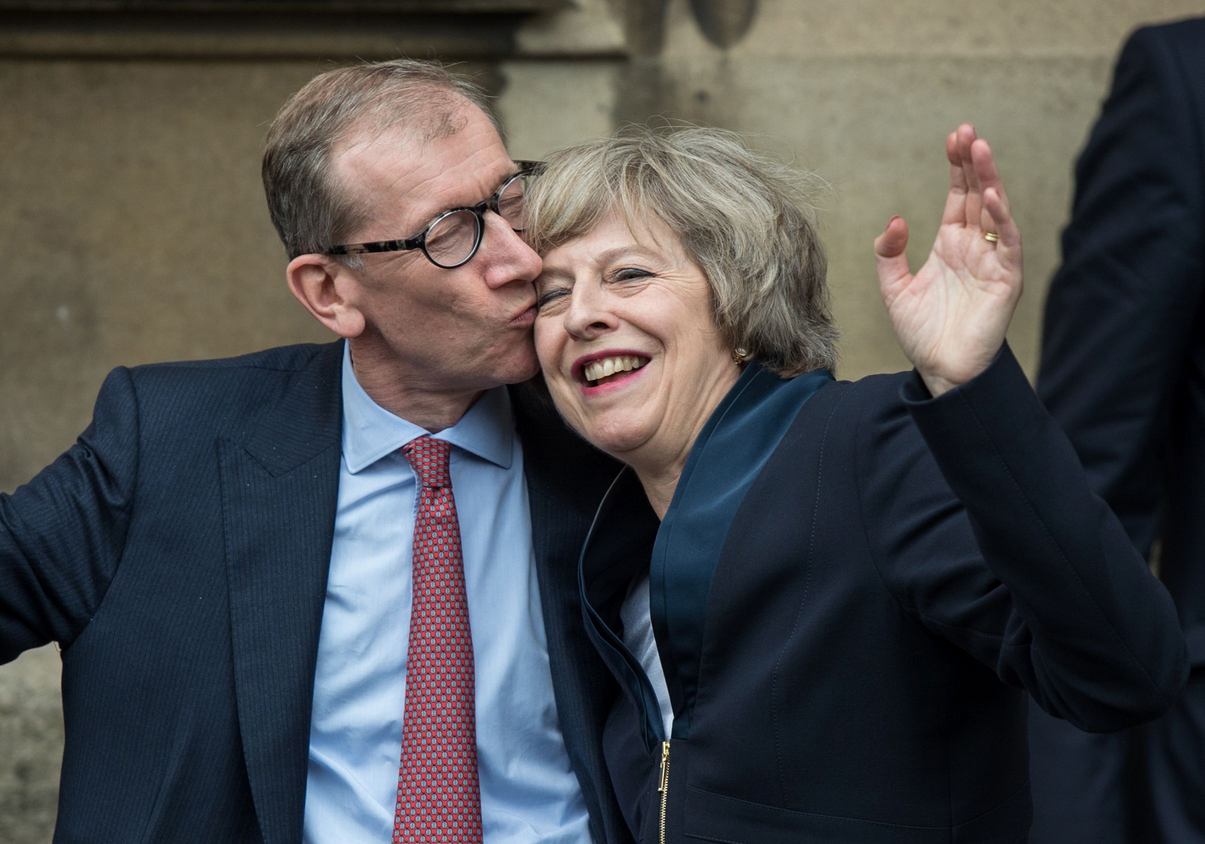 PHOTO: Theresa May receives a kiss from her husband Philip John May after speaking to members of the media at The St Stephen's entrance to the Palace of Westminster in London, July 11, 2016.