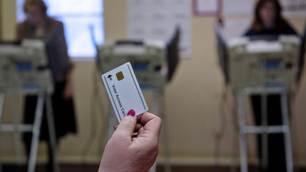 A poll worker waits to give a voter a card necessary for electronic voting in Stark County-Beach City, Ohio on March 15, 2016.