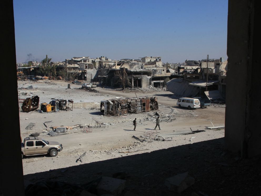 PHOTO: Syrian pro-regime fighters walk in a bombed-out steet in Ramussa on Sept. 9, 2016, after they took control of the strategically important district on the outskirts of the Syrian city of Aleppo the previous day.