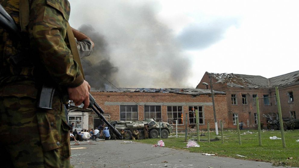 PHOTO: Soldiers and security forces are seen in front of the burning school during the rescue operation in Beslan, nortern Ossetia, Sept. 3, 2004.