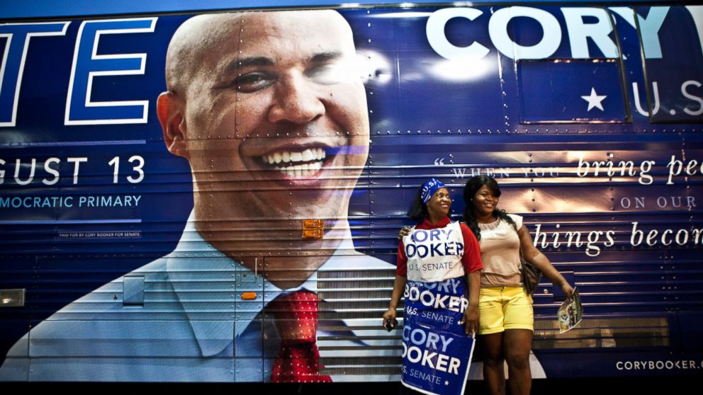  Supporters pose for a picture next to U.S. Senate candidate Cory Booker's campaign bus during a rally, Aug.12, 2013, in Newark, N.J.