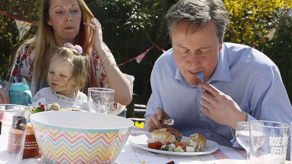 PHOTO: In this file picture taken on April 6, 2015, Britain's Prime Minister David Cameron, right, has a bite to eat with Lilli Docherty and her daughter Dakota in their garden in southern England.