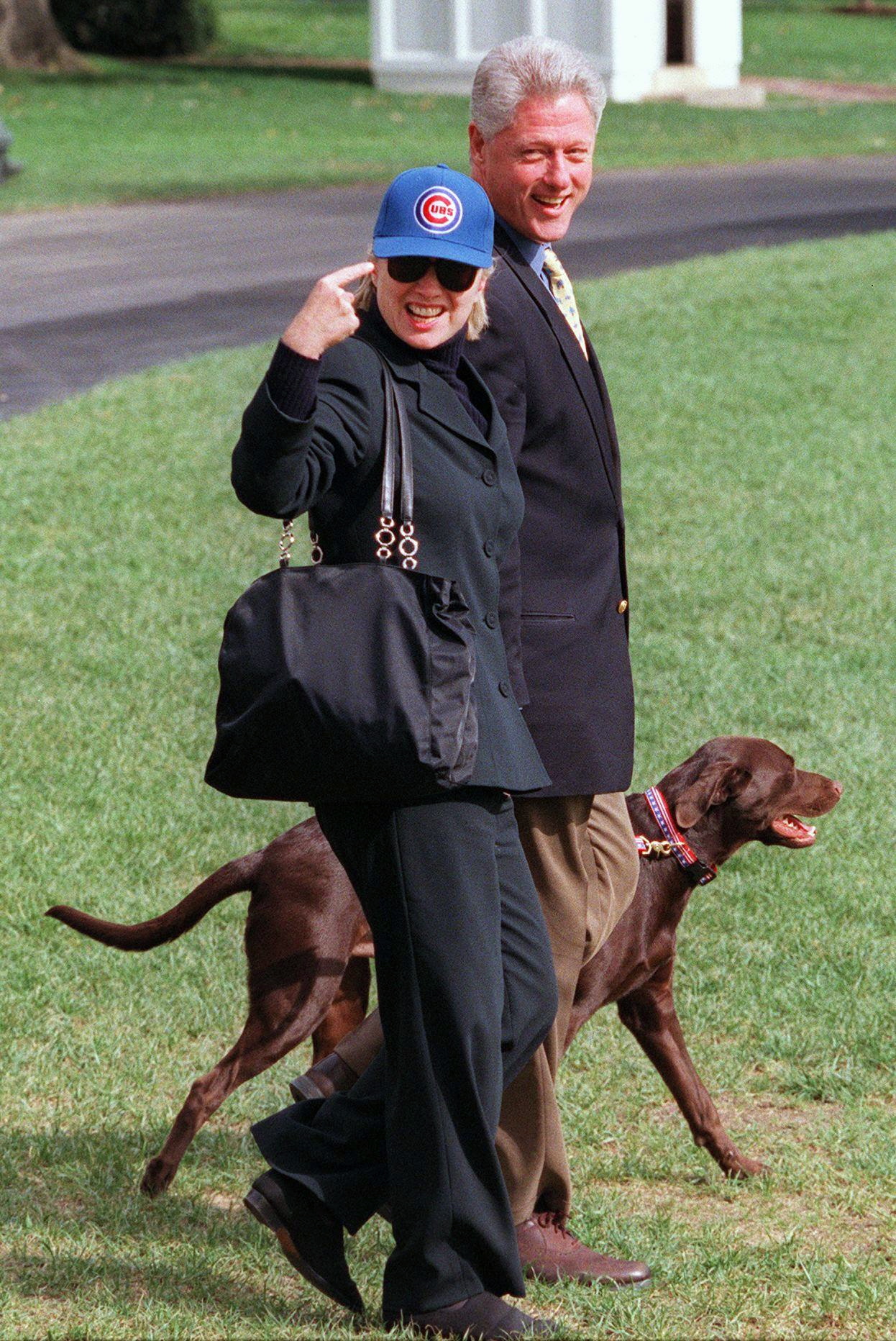 PHOTO: Then first lady Hillary Clinton points to her Chicago Cubs baseball cap on the South Lawn of the White House with husband, then President Bill Clinton and their dog, Buddy, Oct. 3, 1998.