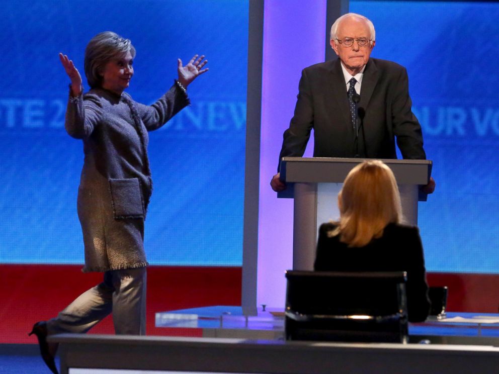 PHOTO: Democratic presidential candidate Bernie Sanders waits as Hillary Clinton walks on stage at Saint Anselm College, Dec.19, 2015 in Manchester, N.H.