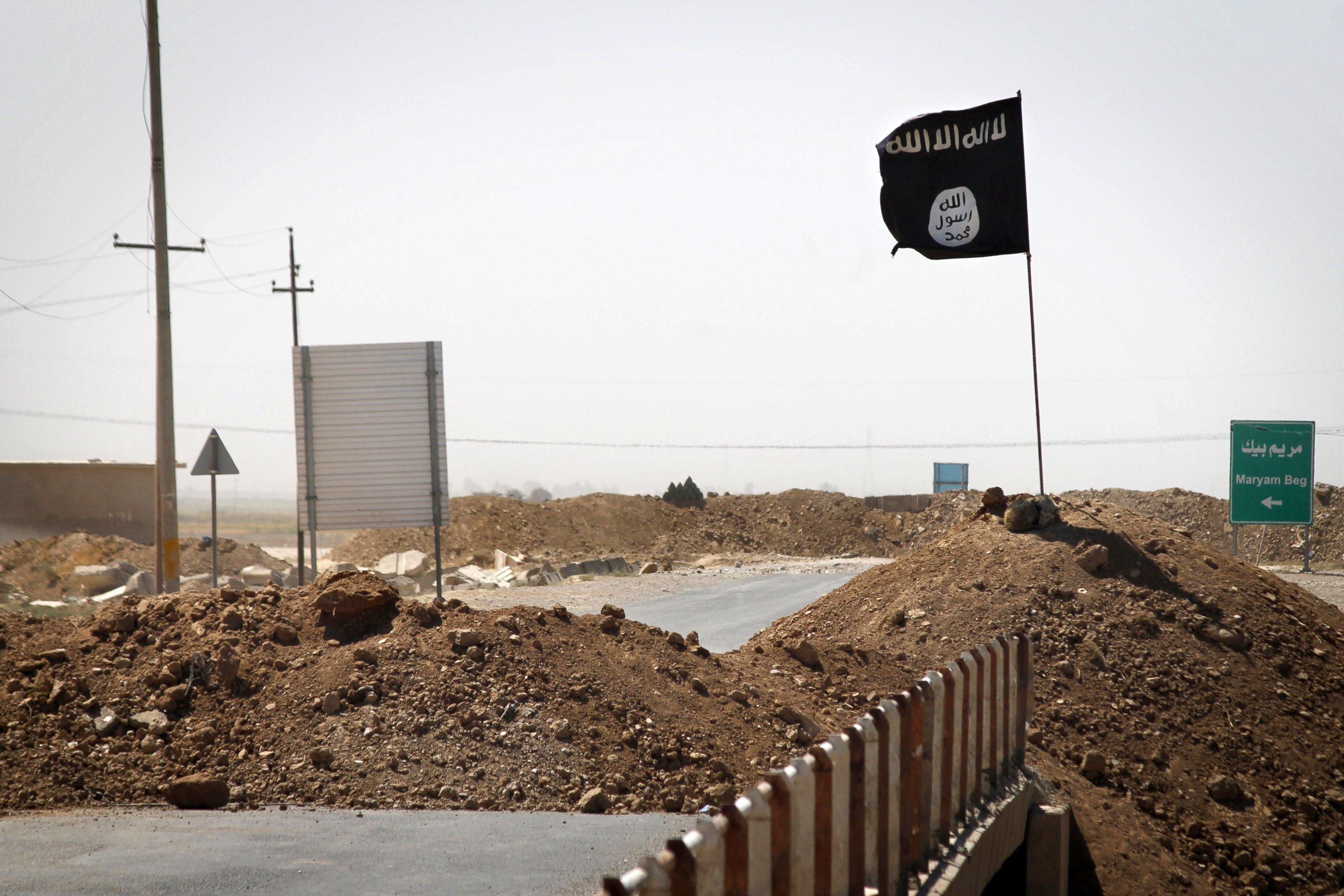 PHOTO: A flag of the Islamic State is seen on the other side of a bridge at the front line of fighting between Kurdish Peshmerga fighters and Islamist militants in Rashad, on the road between Kirkuk and Tikrit, Sept. 11, 2014.