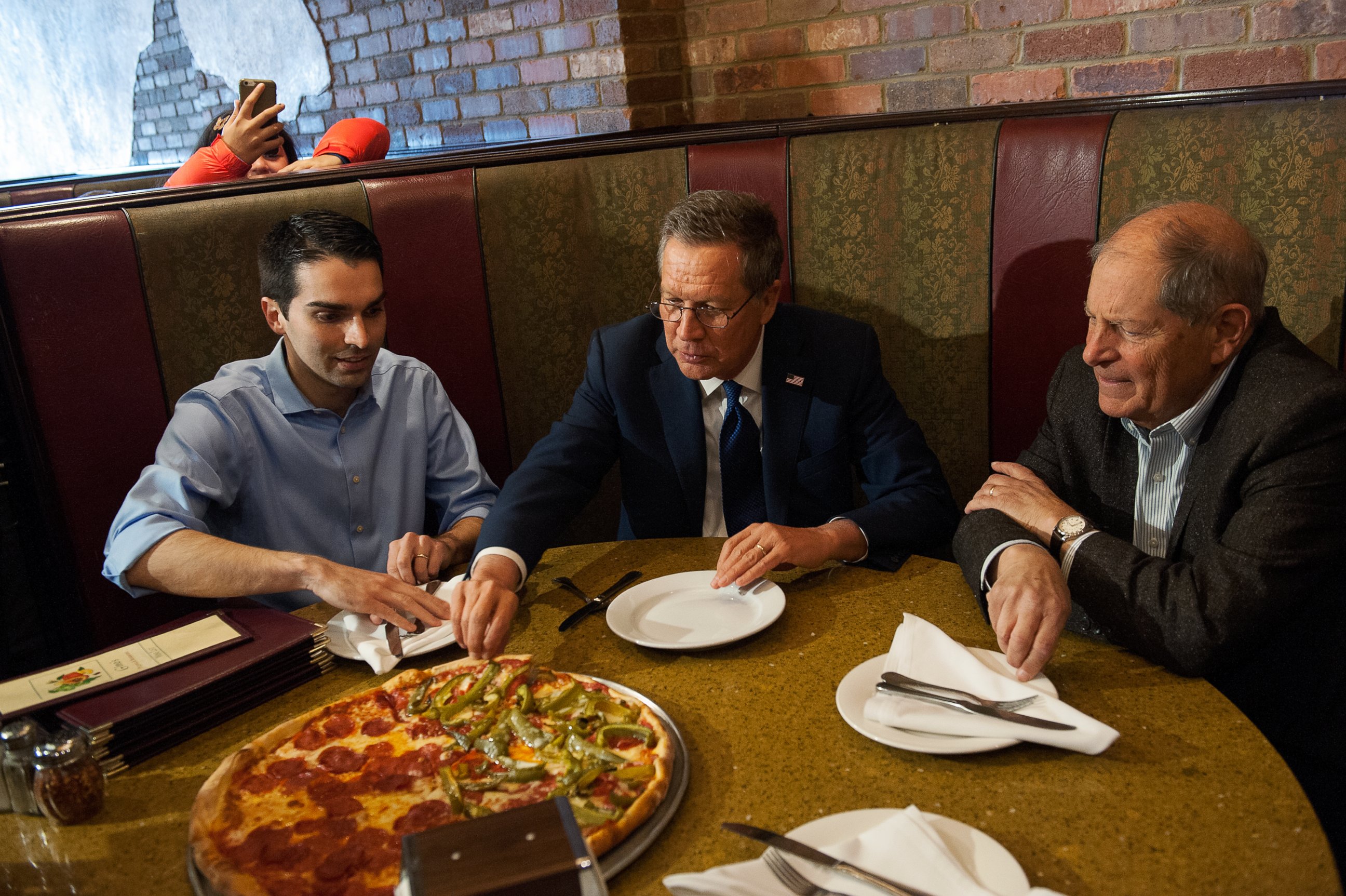 PHOTO: New York City Council member Eric Ulrich, Republican presidential candidate John Kasich, and former Rep. Bob Turner eat at Gino's Pizzeria and Restaurant, March 30, 2016, in the Queens, New York.