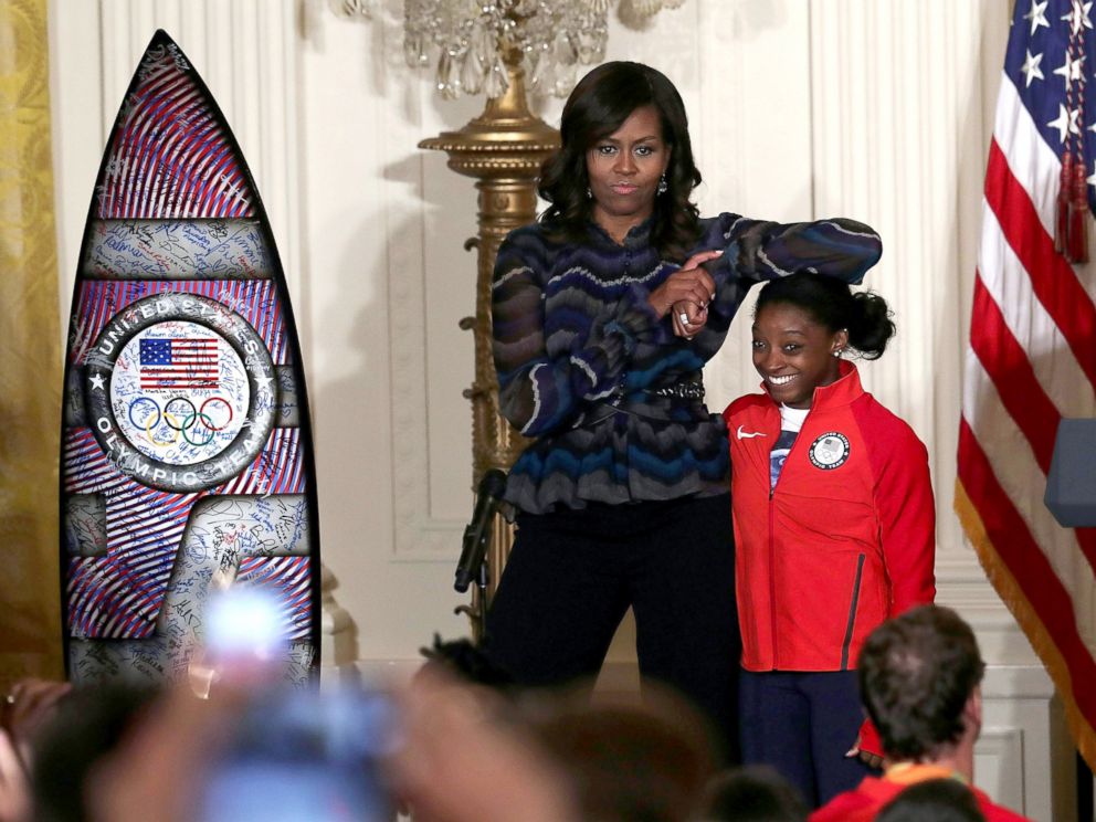 PHOTO: Michelle Obama rests her elbow on the head of Olympian Simone Biles during an East Room event at the White House, Sept. 29, 2016, in Washington.