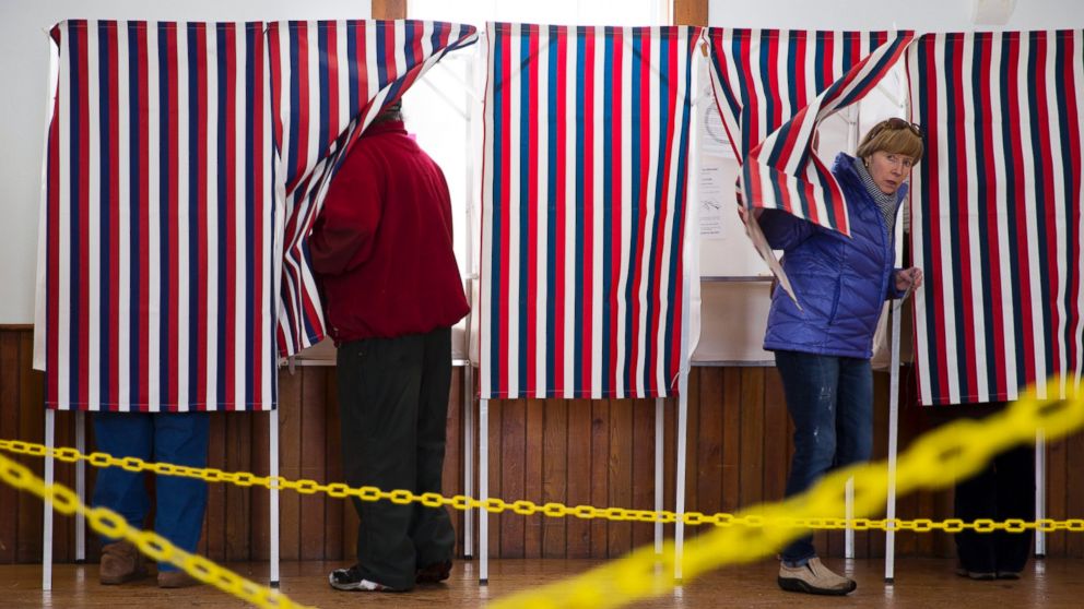 A woman emerges from the voting both, Feb. 9, 2016, in Chichester, N.H. 
New Hampshire voters headed to polls at the snowy break of day Tuesday for the crucial first presidential primary.