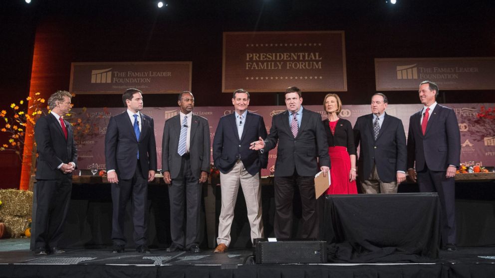 Republican presidential candidates, from left,  Rand Paul, Marco Rubio, Ben Carson, Ted Cruz, moderator Frank Luntz, Carly Fiorina, Mike Huckabee and Rick Santorum stand on stage during the Presidential Family Forum, Nov. 20, 2015, in Des Moines, Iowa. 