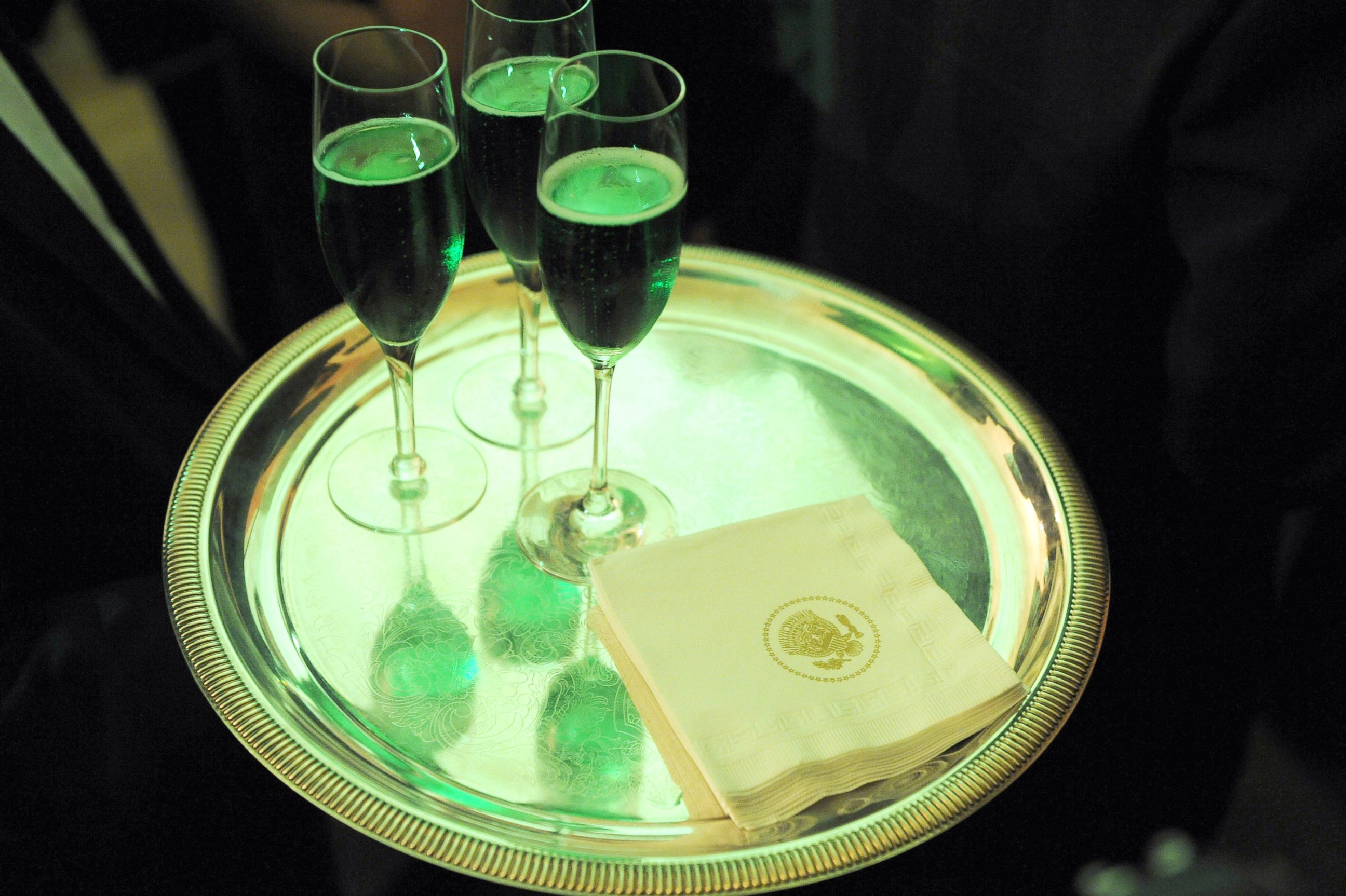 PHOTO: Glasses of green champagne are carried by a waiter during the annual St. Patrick's Day reception in the East Room of the White House, March 17, 2009, in Washington.