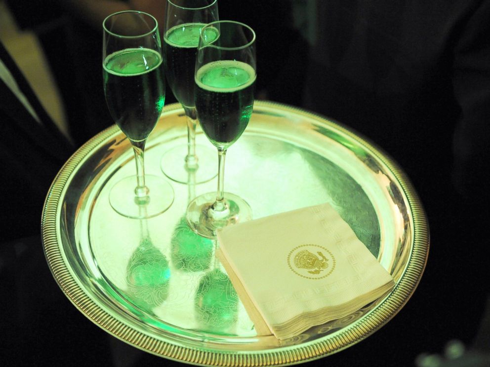 PHOTO: Glasses of green champagne are carried by a waiter during the annual St. Patricks Day reception in the East Room of the White House, March 17, 2009, in Washington.