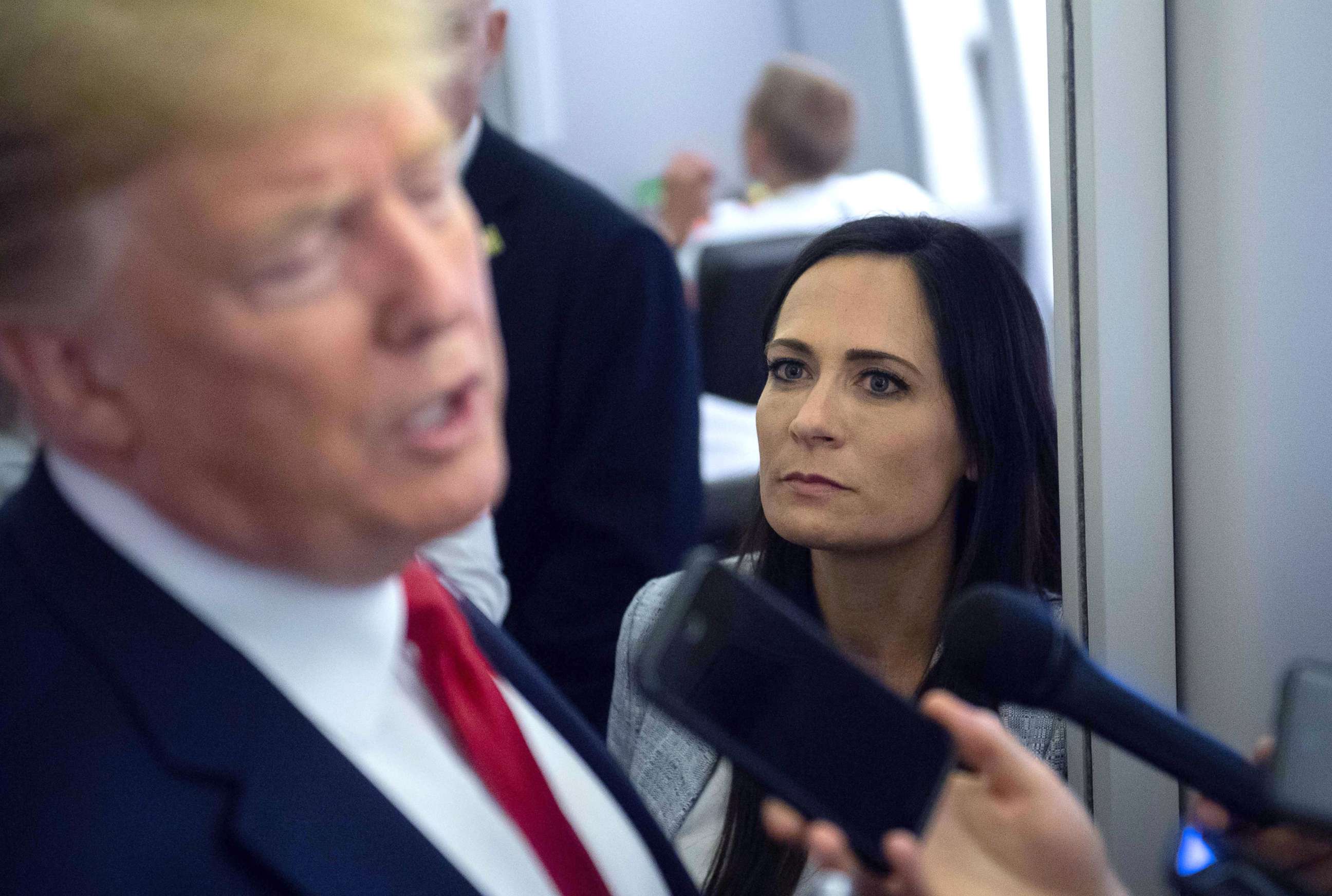 PHOTO: White House Press Secretary Stephanie Grisham listens as President Donald Trump speaks to the media aboard Air Force One while flying between El Paso, Texas and Joint Base Andrews in Md., Aug. 7, 2019. 