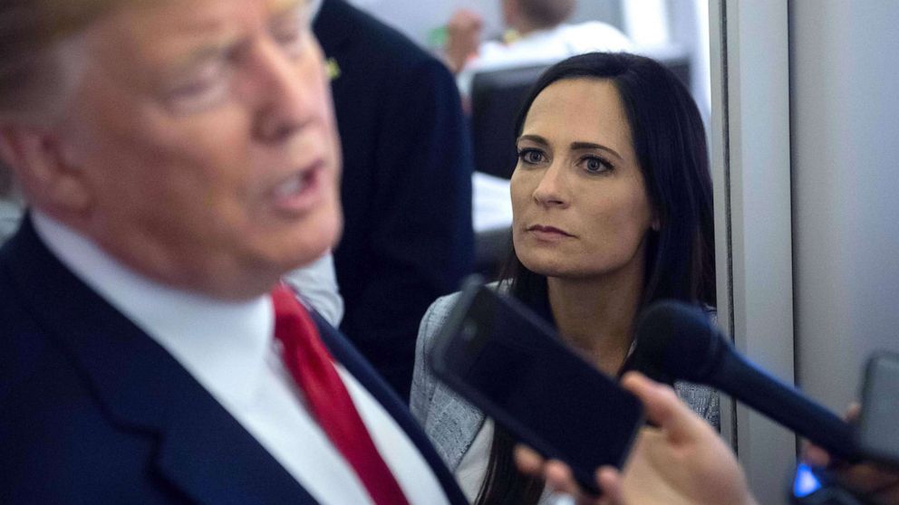 PHOTO: White House Press Secretary Stephanie Grisham listens as President Donald Trump speaks to the media aboard Air Force One while flying between El Paso, Texas and Joint Base Andrews in Md., Aug. 7, 2019. 