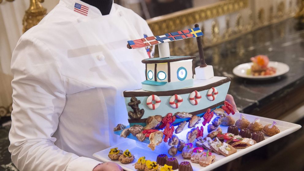 PHOTO: White House pastry chef Susie Morrison holds a dessert featuring a handcrafted fishing boat surrounded by miniature pastries during a press preview of a State Dinner in honor of the Nordic countries, May 12, 2016.