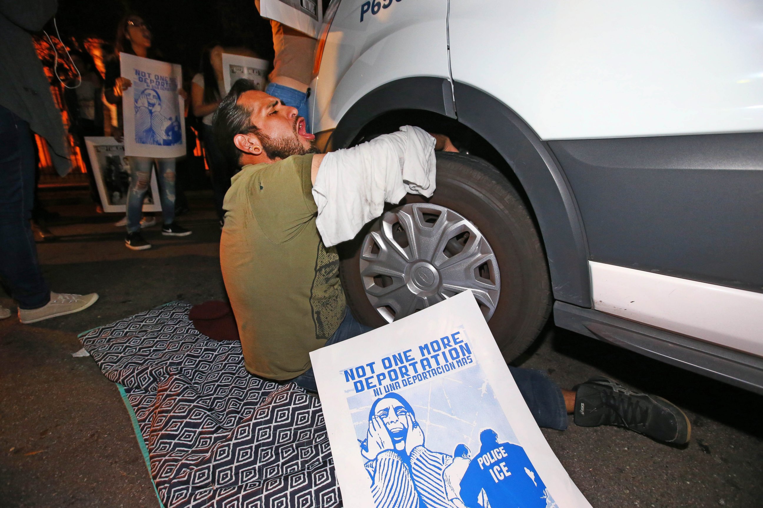 PHOTO: A protester locks himself to the van carrying Guadalupe Garcia de Rayos outside the ICE office in Phoenix, Ariz., Feb. 8, 2017. 