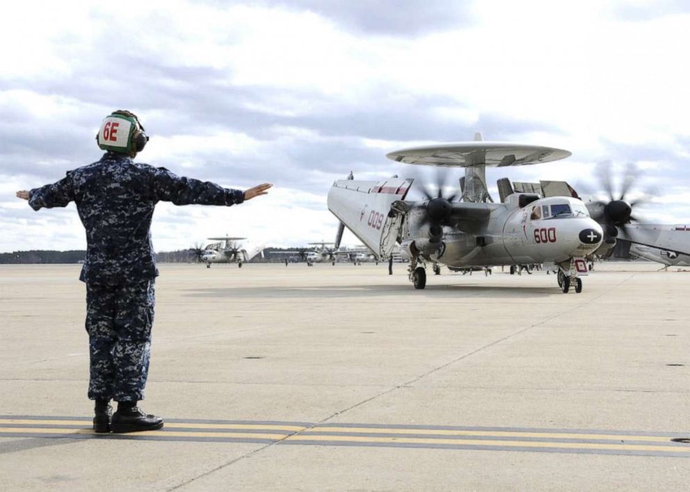 PHOTO: Aviation Electricians Mate 3rd Class Dennies Damaso, directs an E-2C Hawkeye as it returns to Norfolk following a seven-month deployment aboard the aircraft carrier USS George H.W. Bush, Dec. 7, 2011, in Norfolk, Va. 