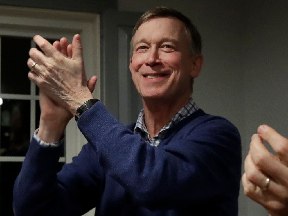 PHOTO: Former Colorado Gov. John Hickenlooper, left, applauds at a campaign house party, Feb. 13, 2019, in Manchester, N.H.