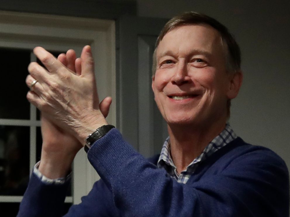 PHOTO: Former Colorado Gov. John Hickenlooper, left, applauds at a campaign house party, Feb. 13, 2019, in Manchester, N.H.