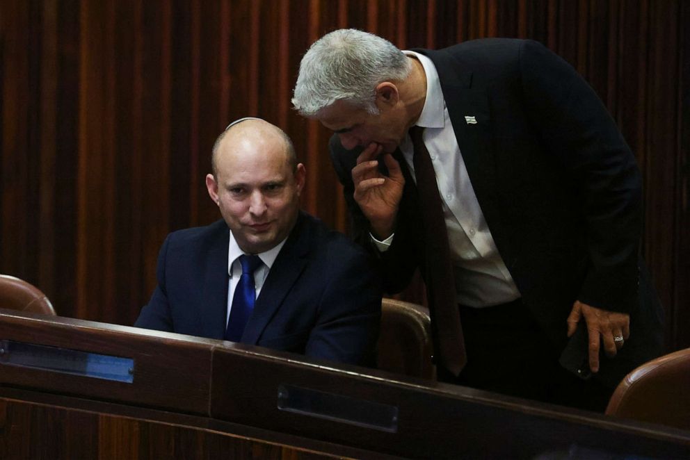 PHOTO: Yamina party leader Naftali Bennett, left, speaks to Yesh Atid party leader Yair Lapid during a special session of the Knesset, whereby Israeli lawmakers elect a new president, at Israel's parliament in Jerusalem, June 2, 2021. 