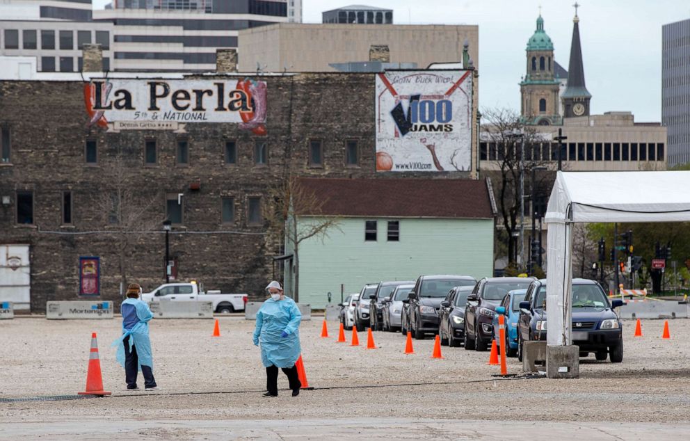 PHOTO: People wait in line for getting drive-through COVID-19 testing, May 14, 2020, in Milwaukee.