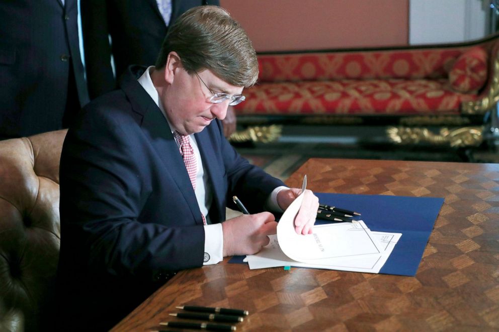 PHOTO: Mississippi Gov. Tate Reeves signs the bill retiring the last state flag with the Confederate battle emblem during a ceremony at the Governor's Mansion in Jackson, Miss., June 30, 2020. 