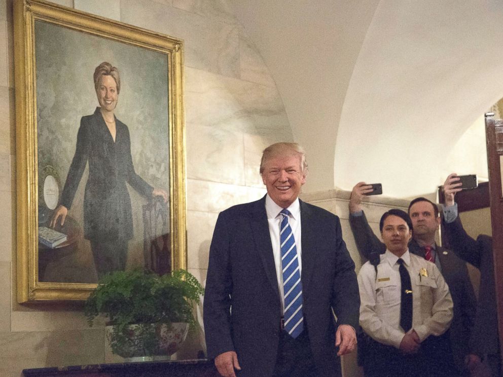 PHOTO: President Donald Trump greets the first new visitors in the Center Hall of the Ground Floor of the White House, in front of the official portrait of former first lady Hillary Clinton, Washington, March 7, 2017.