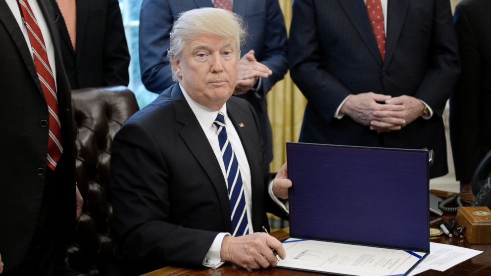 President Donald Trump signs H.J. Res 41, which disapproves a rule mandated by the Dodd-Frank legislation in the Oval Office of the White House, Feb. 14, 2017, in Washington.
