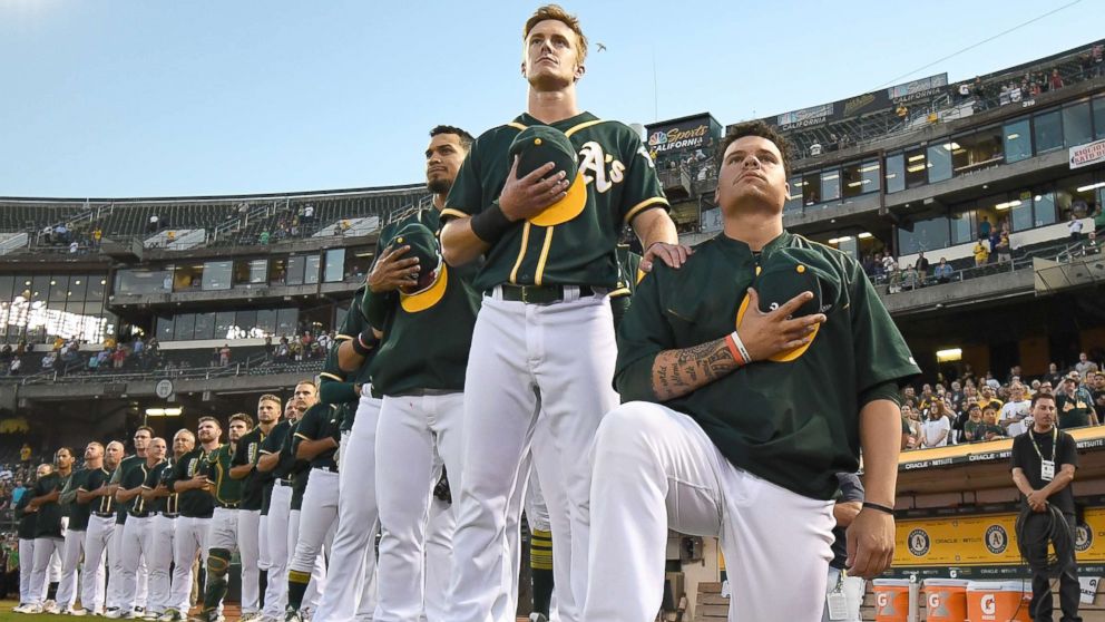 Bruce Maxwell of the Oakland Athletics kneels in protest next to teammate Mark Canha during the singing of the National Anthem prior to the start of the game against the Seattle Mariners at Oakland Alameda Coliseum on Sept. 26, 2017 in Oakland, Calif.