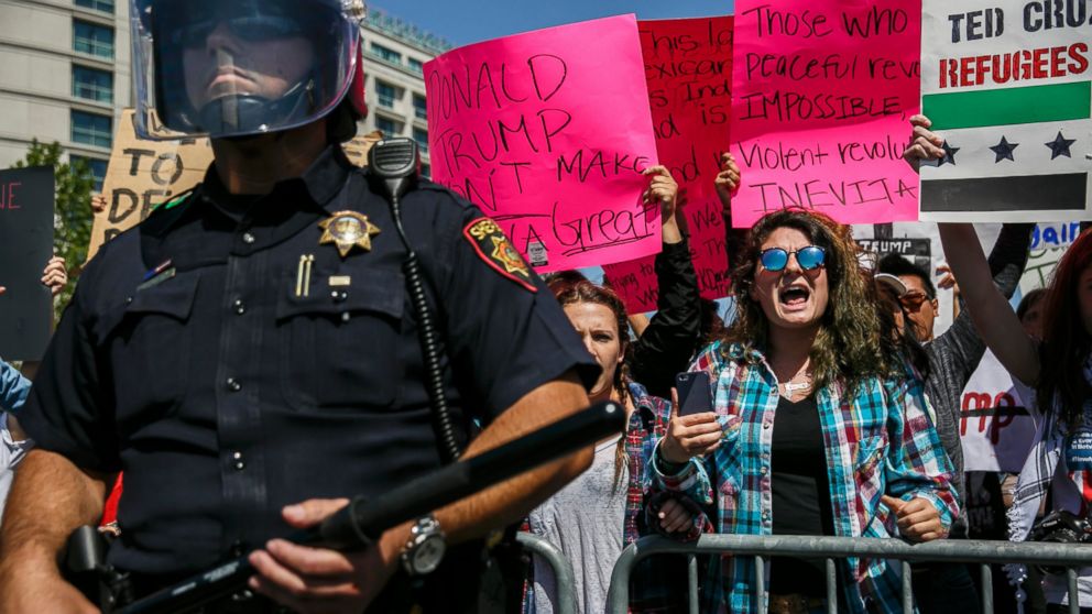 PHOTO: Anti-Trump protesters are blocked by police as they barricade the road outside the California Republican Convention in Burlingame, California, April 29, 2016. 