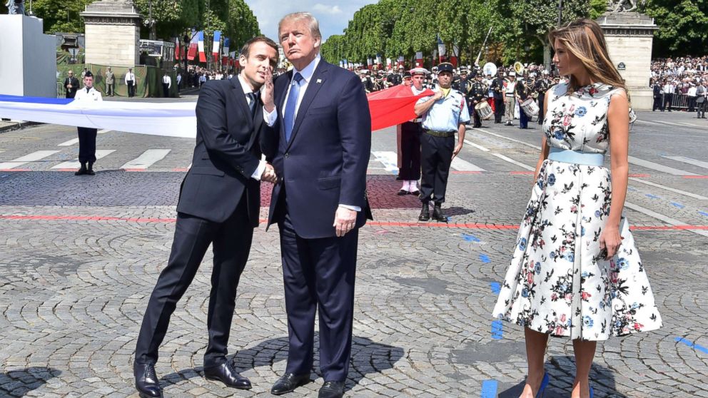 French President Emmanuel Macron shakes hands with President Donald Trump, next to Melania Trump during the Bastille Day military parade in Paris, July 14, 2017.