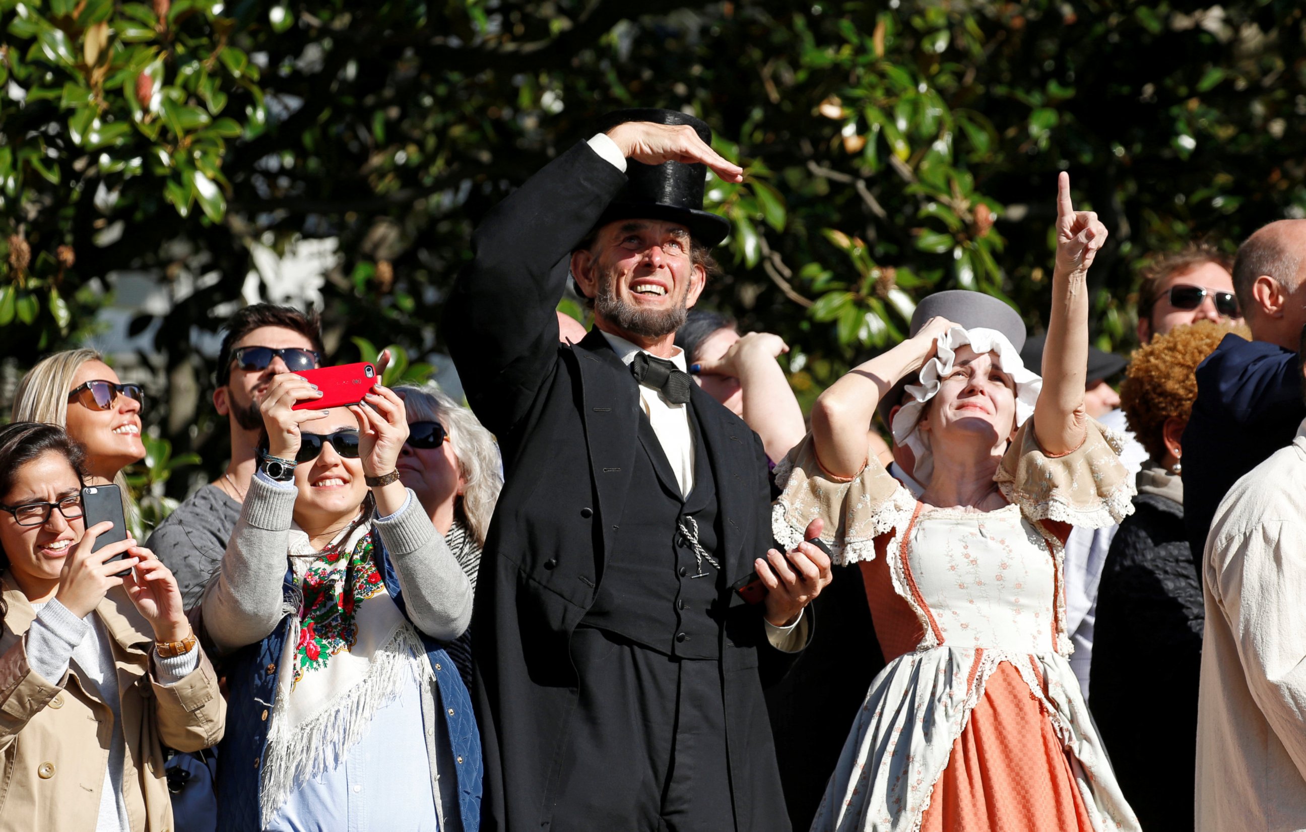 PHOTO: Actors dressed as President Abraham Lincoln, center, and first lady Abigail Adams, right,  look up as they watch President Barack Obama depart the White House aboard Marine One in Washington, D.C. October 28, 2016. 