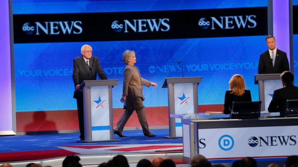 PHOTO: Hillary Clinton, center, walks to her empty podium between rivals Sen. Bernie Sanders, left, and Martin O'Malley after she was late to return for the resumption of the Democratic debate at St. Anselm College in Manchester, N.H., Dec. 19, 2015. 