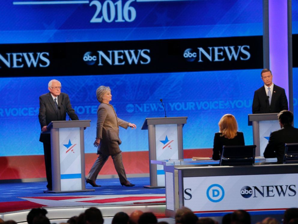 PHOTO: Hillary Clinton, center, walks to her empty podium between rivals Sen. Bernie Sanders, left, and Martin OMalley after she was late to return for the resumption of the Democratic debate at St. Anselm College in Manchester, N.H., Dec. 19, 2015.