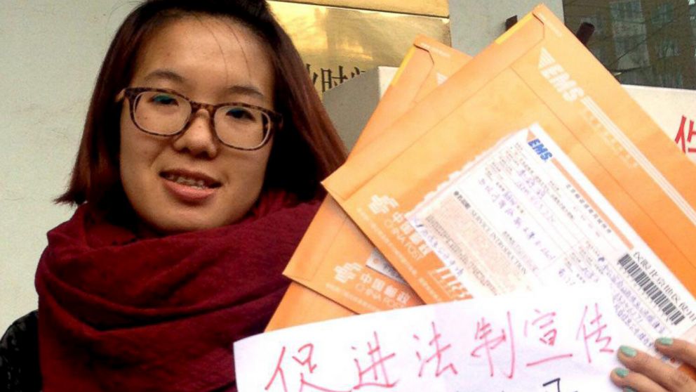 Women activist Wei Tingting, 26, poses for a photograph with letters and a paper which read "push ahead legal advocacy, request information disclosure, domestic violence should be punished by law!" in this undated handout picture taken in an unknown location in China, provided by a women's rights group on April 8, 2015. 