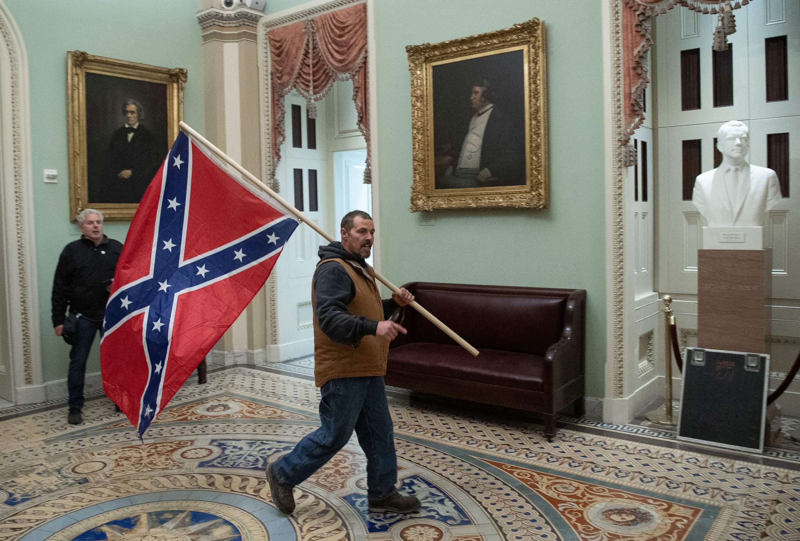PHOTO: Kevin Seefried carries a  Confederate flag as he protestS in the Capitol Rotunda, Jan. 6, 2021.
