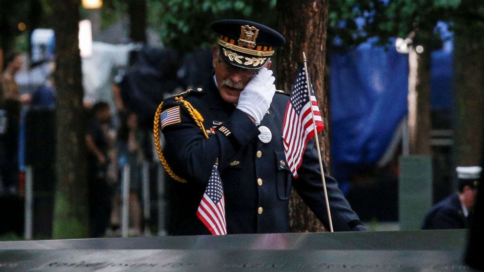 PHOTO: A guest wipes a tear among names at the edge of the south reflecting pool at the National 9/11 Memorial and Museum during ceremonies marking the 17th anniversary of the Sept. 11, 2001 attacks on the World Trade Center in New York.