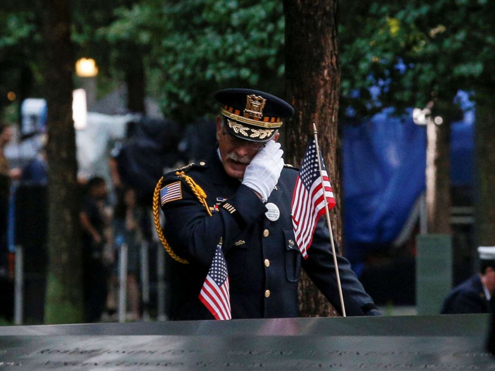 PHOTO: A guest wipes a tear among names at the edge of the south reflecting pool at the National 9/11 Memorial and Museum during ceremonies marking the 17th anniversary of the Sept. 11, 2001 attacks on the World Trade Center in New York.