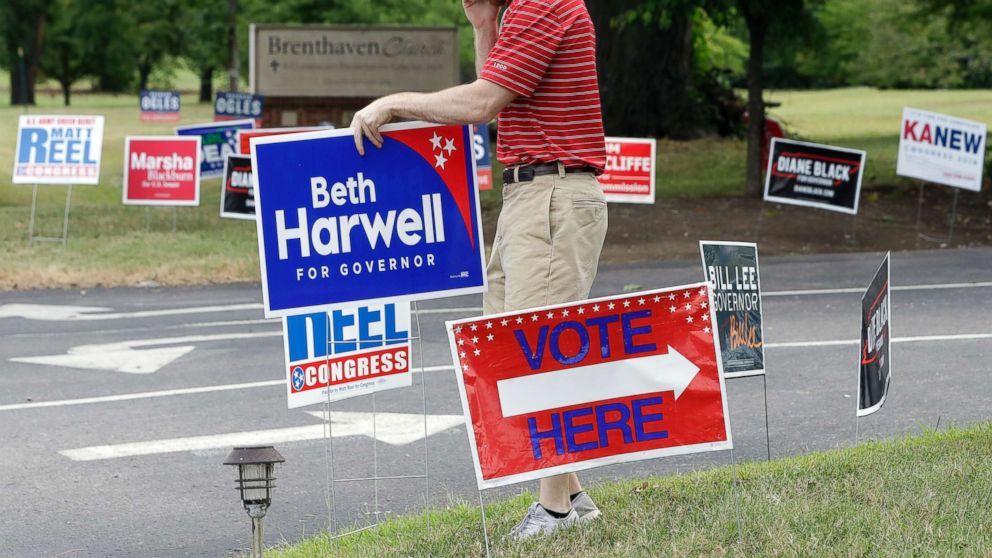 Jacob Baggett places a campaign sign at a polling place, Aug. 2, 2018, in Brentwood, Tenn. With three open seats among Tennessee's nine congressional districts, the state's U.S. House contingent is going to welcome some new faces into the fold. The partial makeover starts with Thursday's primaries.