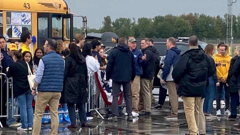 PHOTO: Minnesota Gov. Tim Walz, wearing a camouflage hunting cap, greets students from U-M after his flight arrived in the rain at Willow Run Airport in Michigan, Sept. 28, 2024.