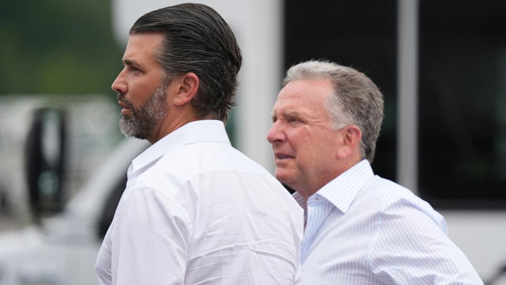 PHOTO: Donald Trump Jr., left, and White House special envoy Steve Witkoff wait before the arrival of President Donald Trump at Teterboro Airport in Teterboro, N.J., en route to attend the Club World Cup final soccer match, Sunday, July 13, 2025.