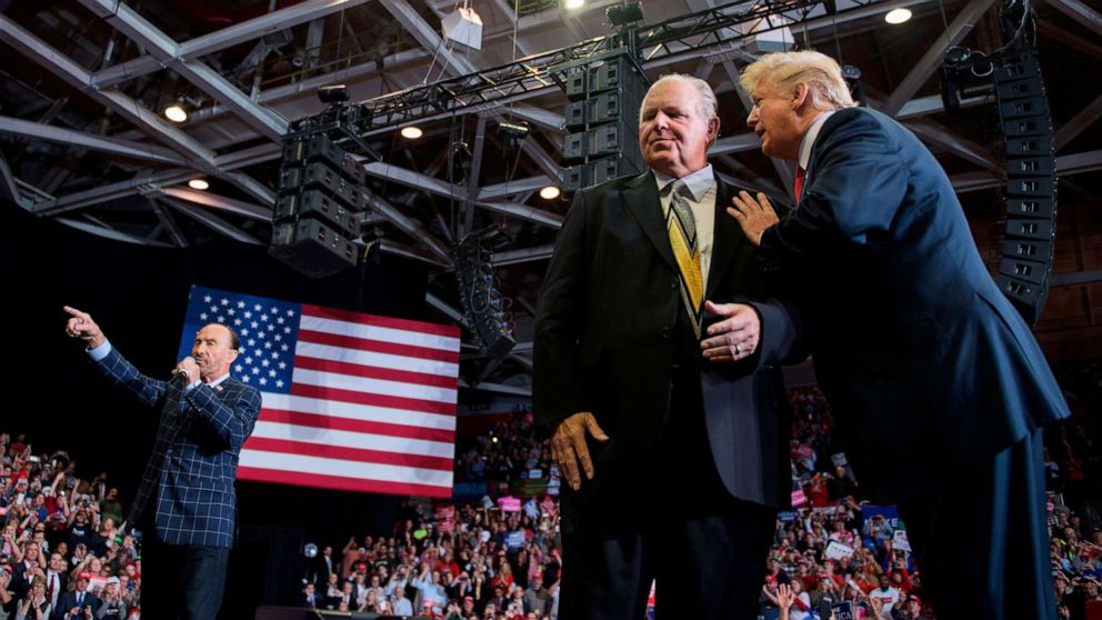 PHOTO: President Donald Trump speaks to radio talk show host Rush Limbaugh, while Lee Greenwood performs "God Bless The USA", at a Make America Great Again rally in Cape Girardeau, Mo., Nov. 5, 2018. 