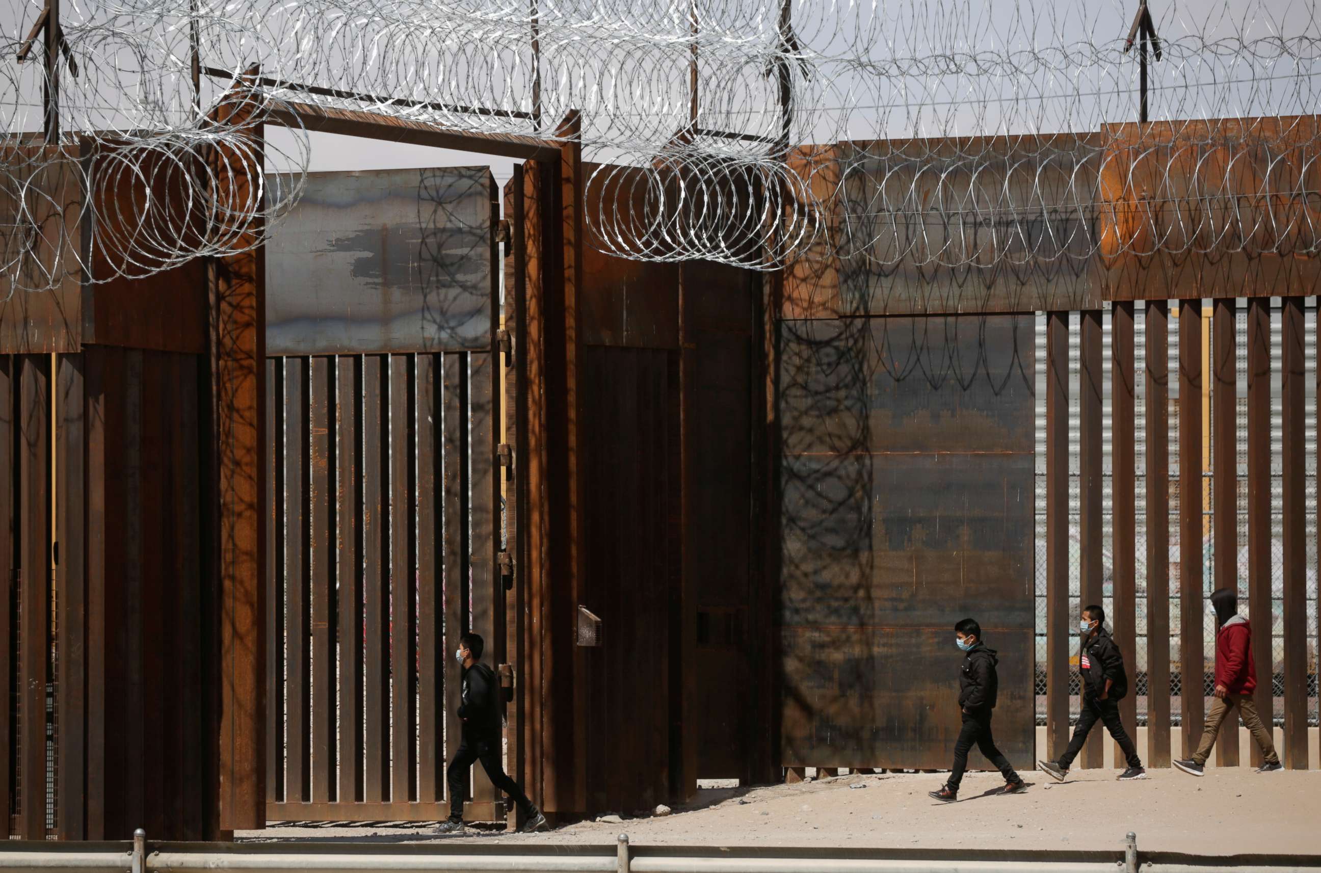 PHOTO: Migrants walk to a gate in the border wall after crossing the Rio Bravo river to turn themselves in to U.S. Border Patrol agents to request for asylum in El Paso, Texas, U.S., as seen from Ciudad Juarez, Mexico March 14, 2021. 