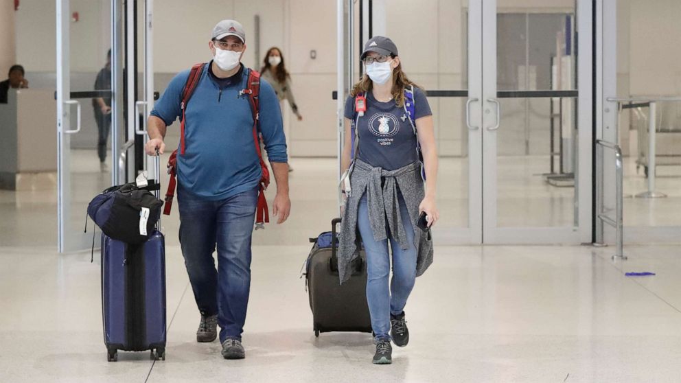 PHOTO: Mike Rustici, left, and Linda Scruggs exit customs after arriving on a flight from Lima, Peru, March 21, 2020, at Miami International Airport in Florida.