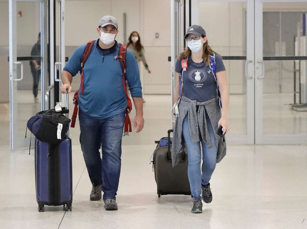 PHOTO: Mike Rustici, left, and Linda Scruggs exit customs after arriving on a flight from Lima, Peru, March 21, 2020, at Miami International Airport in Florida.