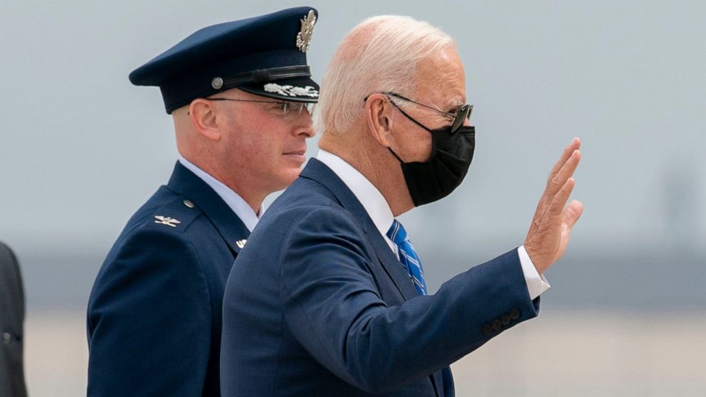 President Joe Biden waves as he is escorted by Col. "Chris" McDonald, the Vice Commander of the 89th Airlift Wing, as he walks to board Air Force One, Tuesday, Oct. 5, 2021, at Andrews Air Force Base, Md.. (AP Photo/Gemunu Amarasinghe)