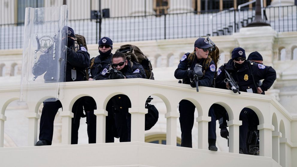 FILE - In this Jan. 6, 2021, file photo, police keep a watch on demonstrators who tried to break through a police barrier at the Capitol in Washington. A blistering internal report by the U.S. Capitol Police describes a multitude of missteps that lef