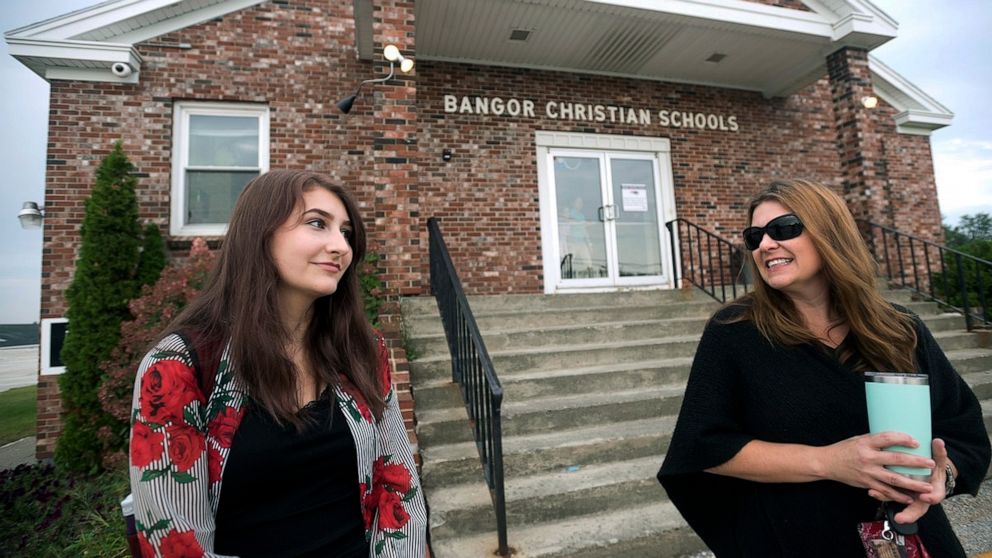 Bangor Christian Schools sophomore Olivia Carson, 15, of Glenburn, Maine, left, stands with her mother Amy while getting dropped off on the first day of school on August 28, 2018 in Bangor, Maine. The Carsons were one of three Maine families that cha