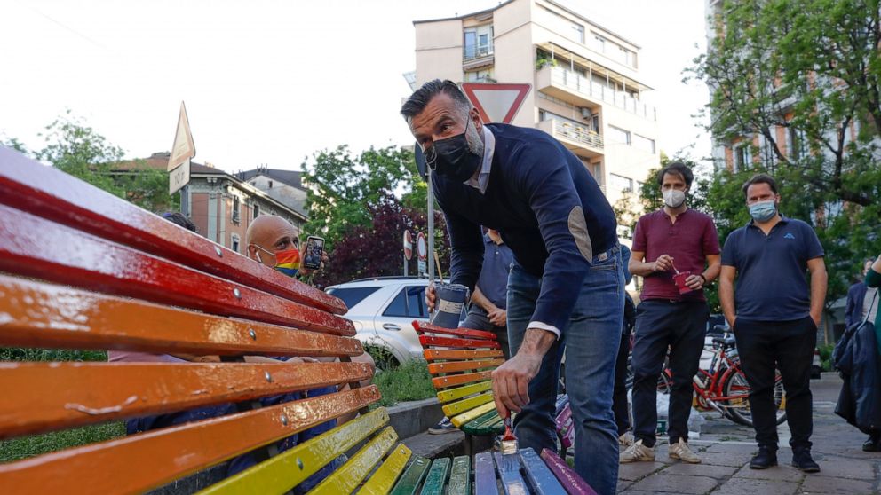 FILE - In this Friday, May 7, 2021 filer, Italian lawmaker Alessandro Zan paints a bench in the colors of the rainbow, in Milan, Italy. The Vatican has formally opposed proposed Italian legislation that seeks expand anti-discrimination protections to